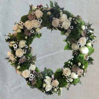 Heart-shaped floral wreath with white roses and green moss
