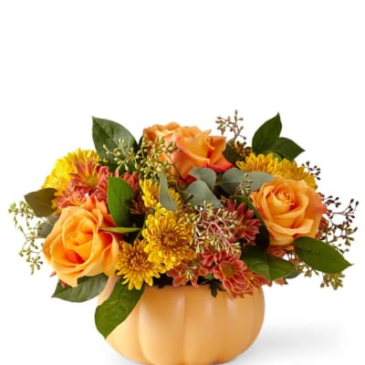 Orange roses and yellow mums in a pumpkin-shaped vase