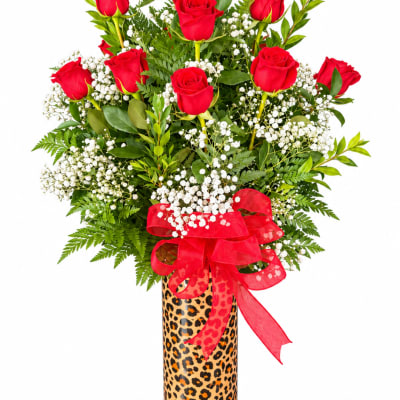 Red roses in a leopard-print vase with a red ribbon