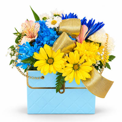 Bright mixed bouquet in a blue gift box with gold ribbon