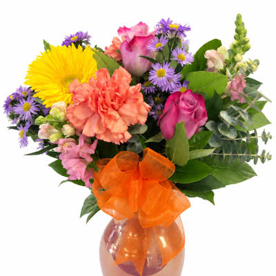 Mixed bouquet in a pink vase with an orange bow
