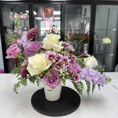 Lavender and cream rose bouquet in a white vase