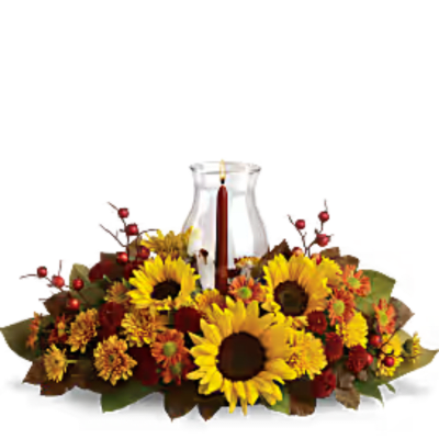 Autumn floral centerpiece with sunflowers around a glass candle holder