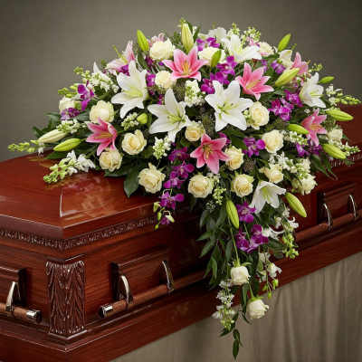 Casket spray with white lilies, cream roses, and pink orchids