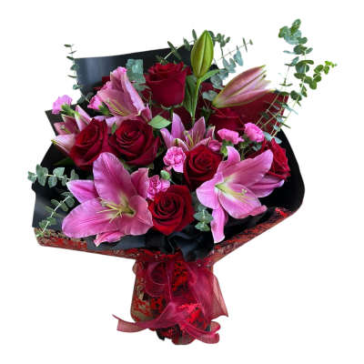 Bouquet of red roses and pink lilies wrapped in black paper