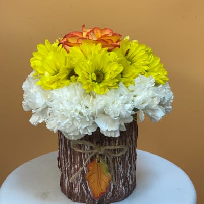 Yellow and white flowers with an orange rose in a rustic vase