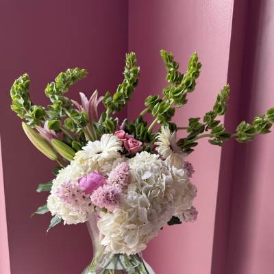 Pink and white flower arrangement in a clear glass vase