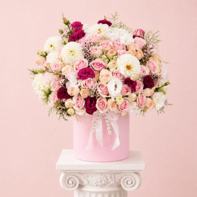 Pink and white rose bouquet in a pink hatbox with ribbon and pearls