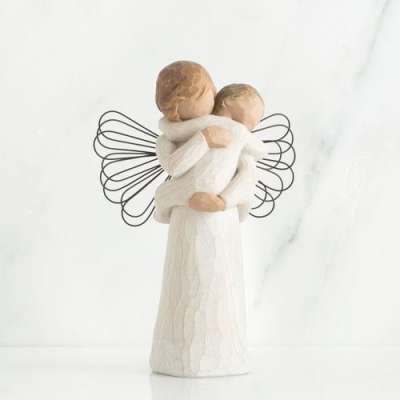Wooden-style angel figurine holding a child with wire wings in soft neutral tones.
