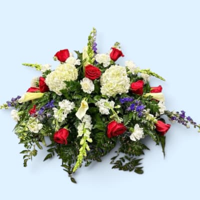 Red roses with white hydrangeas and purple flowers in a low arrangement