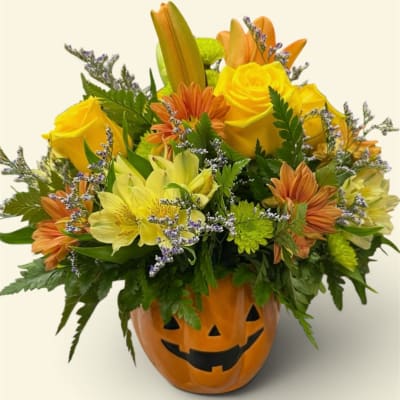 Yellow and orange mixed bouquet in a jack-o'-lantern pumpkin container