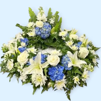 White and blue floral wreath with lilies, roses, and daisies