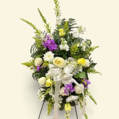Standing floral spray with white, yellow, and purple flowers on an easel