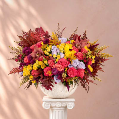 Colorful bouquet of roses and orchids in a white vase