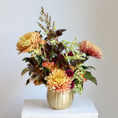 Autumn bouquet of peach and pink chrysanthemums in a gold vase