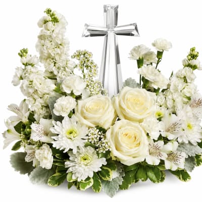 White floral arrangement with roses and a silver cross centerpiece