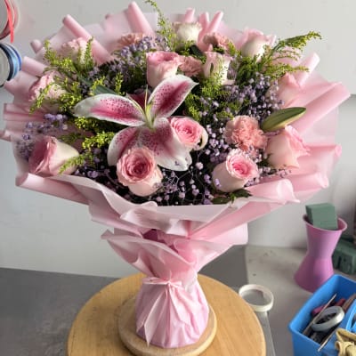 Pink bouquet with roses, lilies, and carnations wrapped in pink paper