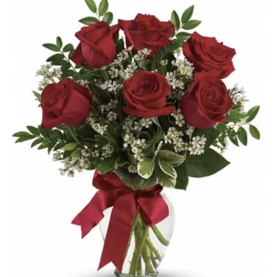 Bouquet of red roses with white filler flowers in a clear glass vase