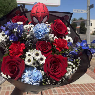 Bouquet of red roses, blue carnations, and white daisies with a Spider-Man plush