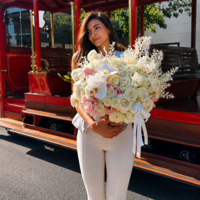 Woman holding a large bouquet of white and blush flowers