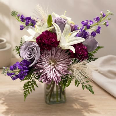 Lavender and white flower arrangement in a glass vase
