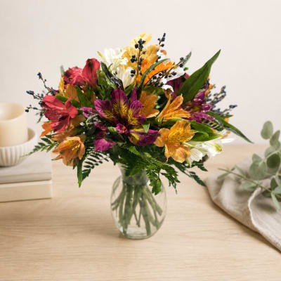 Mixed bouquet of colorful flowers in a clear glass vase