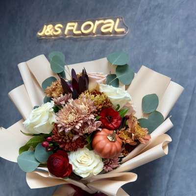 Hand-tied bouquet of roses, chrysanthemums, and a small pumpkin wrap