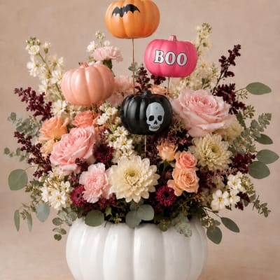 Halloween floral arrangement in a white pumpkin vase with decorative pumpkin picks