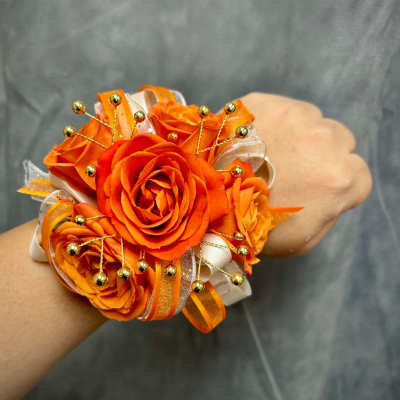 Orange rose wrist corsage with ribbon and gold bead accents