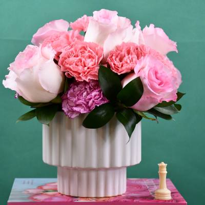 Pink roses and carnations in a white ribbed vase