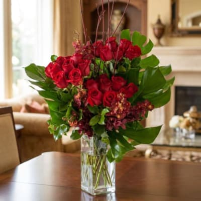 Red roses arranged in a clear glass vase
