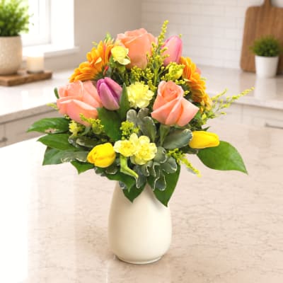Mixed bouquet of roses and tulips in a white vase