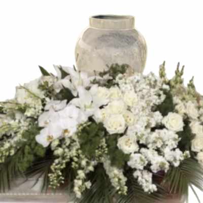 White floral arrangement with orchids and roses around a vase