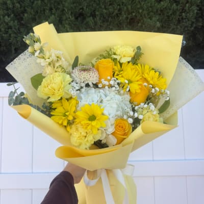 Yellow bouquet with roses, daisies, carnations, and white hydrangea