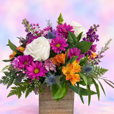 Mixed bouquet with white roses, purple daisies, and orange alstroemeria in a wooden box