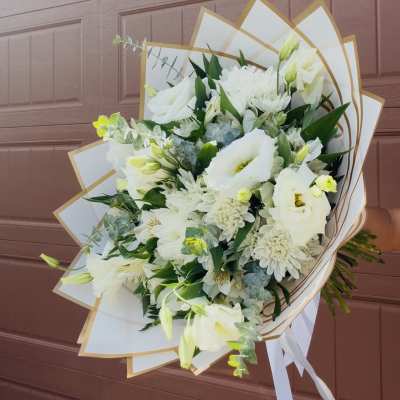 White bouquet with lilies and daisies wrapped in white paper