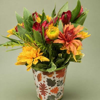Mixed autumn flowers in a leaf-patterned metal pot