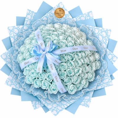 Bouquet of pale blue roses wrapped in patterned blue paper with a ribbon