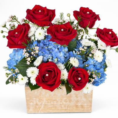 Red roses and blue hydrangeas in a wooden box