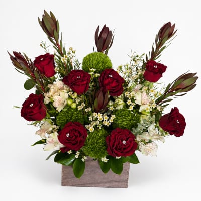 Red roses and white flowers arranged in a wooden box