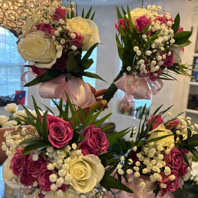 Handheld bouquets of white and pink roses with baby's breath and ribbon