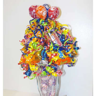 Candy bouquet in a clear glass vase with colorful curled ribbons