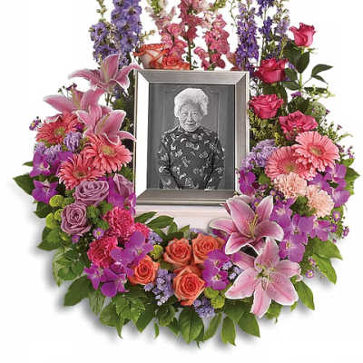 Floral photo frame wreath with pink lilies, roses, and purple flowers
