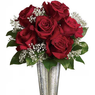 Red roses arranged in a clear glass vase with white filler flowers