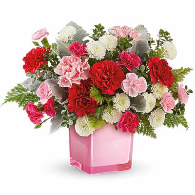 Pink and red carnations in a pink glass vase