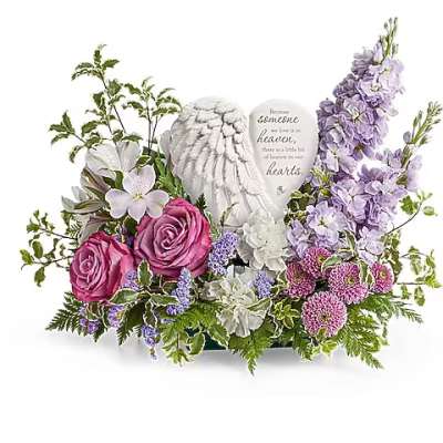 Pink roses and lavender flowers arranged around angel wings and a heart plaque