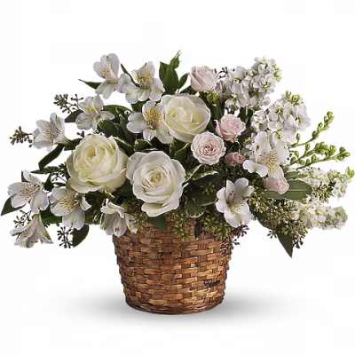 White roses and small white flowers in a woven basket