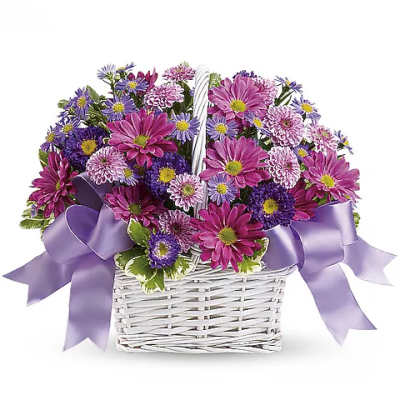 Purple and pink mixed flowers in a white wicker basket with lavender ribbon