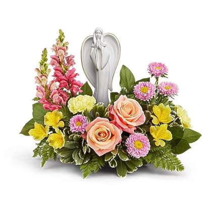 Pink and yellow floral arrangement with a white angel figurine