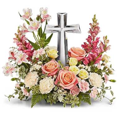 Floral arrangement with a silver cross and pink roses